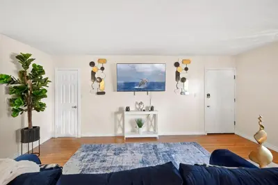 a living room with a blue couch and a painting on the wall at Steps to the Beach - Games - Free Parking in Long Beach