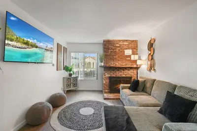 a living room with a couch and a fireplace at Steps to Beach - Beach Essentials Provided! in Long Beach