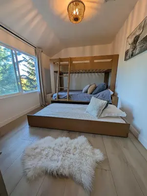 a bedroom with a bed and a rug on the floor at Yama Cabin - 5 min walk to the village, EV plug, hot tub, kid & pet friendly in Lake Arrowhead