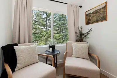 a living room with two chairs and a window at Yama Cabin - 5 min walk to the village, EV plug, hot tub, kid & pet friendly in Lake Arrowhead