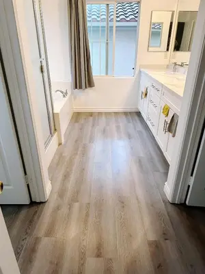 a bathroom with wooden flooring and white cabinets at Big master bedroom private bathroom in Fontana