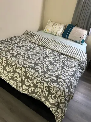 a bed with a black and white comforter on it at Big master bedroom private bathroom in Fontana