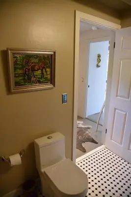 a bathroom with a toilet and a picture on the wall at Hollywood Hills Duplex with view and parking! in Los Angeles