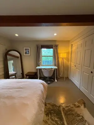 a bedroom with a bed and a mirror and a window at Hollywood Hills Duplex with view and parking! in Los Angeles
