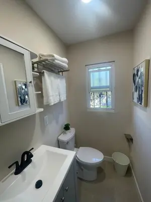a bathroom with a toilet and a sink and a window at \u6c11\u5bbf\u963f\u5c14\u7f55\u5e03\u62c9888 in Alhambra