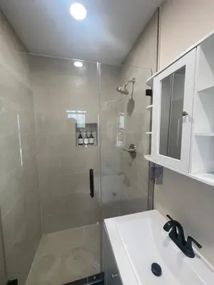a bathroom with a shower and a white sink at \u6c11\u5bbf\u963f\u5c14\u7f55\u5e03\u62c9888 in Alhambra