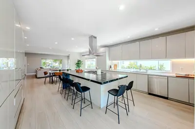 a kitchen with a large island with bar chairs at Modern 5 Bed with Guest House & Pool West Hollywood in Los Angeles