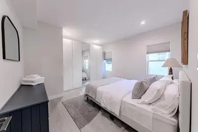 a white bedroom with a large bed and a desk at Modern 5 Bed with Guest House & Pool West Hollywood in Los Angeles