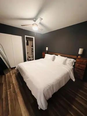a bedroom with a large white bed with a ceiling fan at Stunning Oasis with Pool by Disneyland and Knotts in Buena Park
