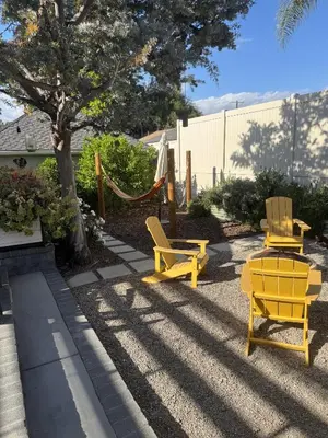 two yellow chairs and a hammock in a yard at NEW Cozy Studio City Guesthouse in Prime Location in Studio City