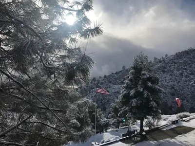 an american flag flying in front of a snow covered mountain at Camp David in Wofford Heights