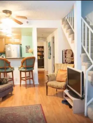 a living room with a television and a staircase at Ocean Condo Penthouse with Gym & Parking in Long Beach