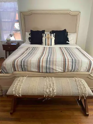 a large bed with a striped comforter and a bench at 2BR LA Beach City House With Gym & Tesla Charging in Harbor City