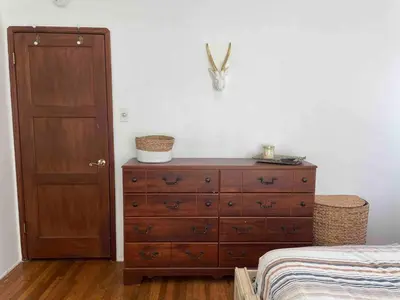 a bedroom with a dresser and a bed and a door at 2BR LA Beach City House With Gym & Tesla Charging in Harbor City