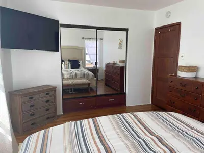 a bedroom with a dresser and a large mirror at 2BR LA Beach City House With Gym & Tesla Charging in Harbor City