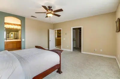 a bedroom with a bed and a ceiling fan at Pool, Patio and Games! Suburban Home in Palmdale in Palmdale