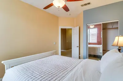 a bedroom with a white bed and a ceiling fan at Pool, Patio and Games! Suburban Home in Palmdale in Palmdale