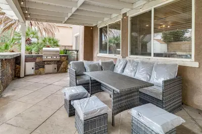 a patio with a table and chairs on a patio at Pool, Patio and Games! Suburban Home in Palmdale in Palmdale