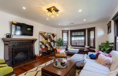 a living room with a fireplace and a tv at Historical Craftsman with Modern Amenities in Los Angeles