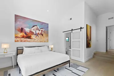 a bedroom with a bed and a painting on the wall at Luxury 4BR Villa with Private Pool in Los Angeles Crescent Heights in Los Angeles