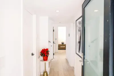 a hallway with white walls and a vase with red flowers at 2BR Luxury Villa in West Hollywood with Private Pool in Los Angeles