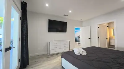 a bedroom with a bed and a tv on the wall at Sleek 7BR Exquisite Estate Resort Pool, Sauna, Spa 6500 SQF in Woodland Hills