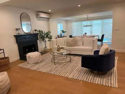 a living room with a white couch and a fireplace at Quintessential SoCal indoor outdoor living with POOL in Long Beach