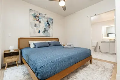a bedroom with a bed with a blue comforter at Cozy 2B Apartment in Santa Monica in Los Angeles
