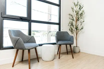 two chairs sitting in a room with windows at Cozy 2B Apartment in Santa Monica in Los Angeles