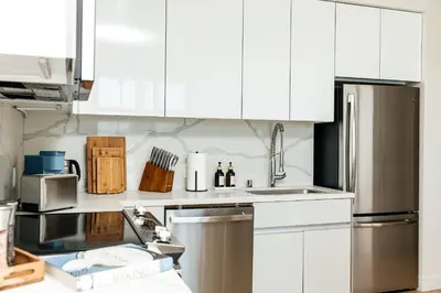 a kitchen with white cabinets and stainless steel appliances at Cozy 2B Apartment in Santa Monica in Los Angeles