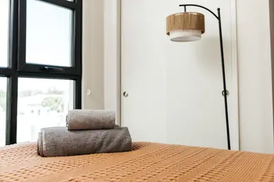 a bedroom with a bed with a lamp and two pillows at Cozy 2B Apartment in Santa Monica in Los Angeles