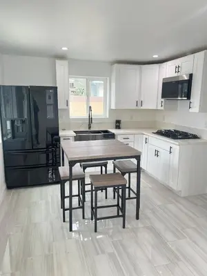 a kitchen with white cabinets and a table and chairs at Cozy home in Norwalk