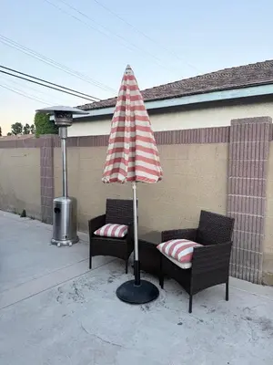 a patio with two chairs and an umbrella at Cozy home in Norwalk