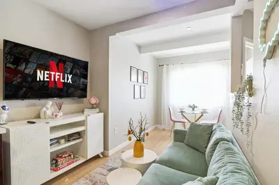 a living room with a couch and a tv at Sunny Santa Monica Retreat, Walk to Beach in Santa Monica