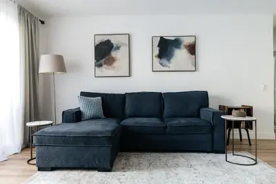 a blue couch in a living room with paintings on the wall at Pacific Aura in Los Angeles