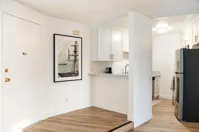a kitchen with white cabinets and a black refrigerator at Pacific Aura in Los Angeles