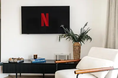 a living room with a chair and a table with a n on the wall at Pacific Aura in Los Angeles
