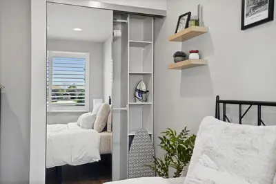 a mirror in a room with a bed and a chair at A Fresh, Relaxing Oasis Near Monrovia Canyon Park in Duarte