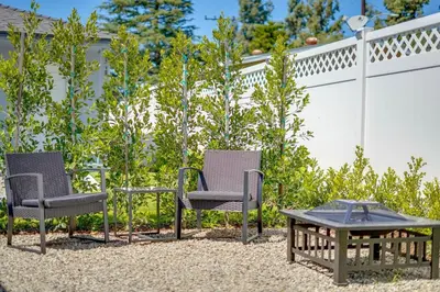 a patio with two chairs and a table and a fence at A Fresh, Relaxing Oasis Near Monrovia Canyon Park in Duarte