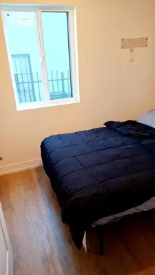 a bed in a room with a large window at Normandie Vibes Hostel in Los Angeles