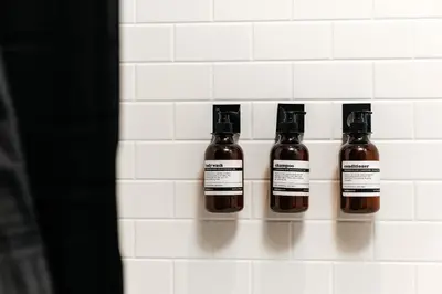 three bottles of liquid on a wall in a bathroom at West Hollywood Luxe Townhome Walkable WeHo Avalon in Los Angeles
