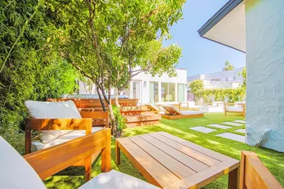 a backyard with benches and a table and a tree at Chic 6BR West Hollywood Villa with Jacuzzi in Los Angeles