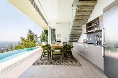 a kitchen with a table and chairs next to a swimming pool at Hillside 4B Villa w Infinity Pool City Views in Los Angeles
