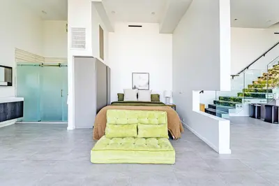 a bedroom with a bed and a yellow chair at Hillside 4B Villa w Infinity Pool City Views in Los Angeles
