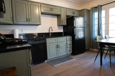 a kitchen with white cabinets and a black refrigerator at Curated Central Location LA in Los Angeles