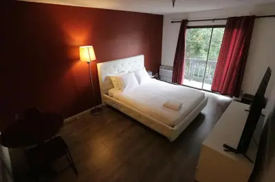 a bedroom with a white bed and a window at Cozy Beverly Hills Hotel Style apartment in Los Angeles