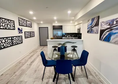 a dining room with a glass table and blue chairs at Cozy Century City 2 Br Sleeps 6 with Parking 505 in Los Angeles
