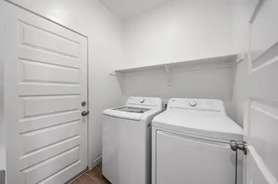 a white laundry room with a washer and a closet at Serenity House- Newly Built, Peaceful Stay in Bakersfield