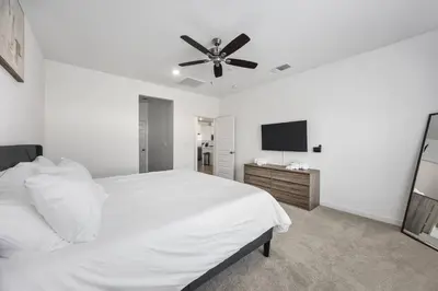a white bedroom with a bed and a ceiling fan at Serenity House- Newly Built, Peaceful Stay in Bakersfield