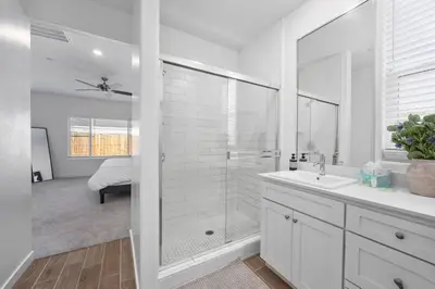 a white bathroom with a shower and a sink at Serenity House- Newly Built, Peaceful Stay in Bakersfield